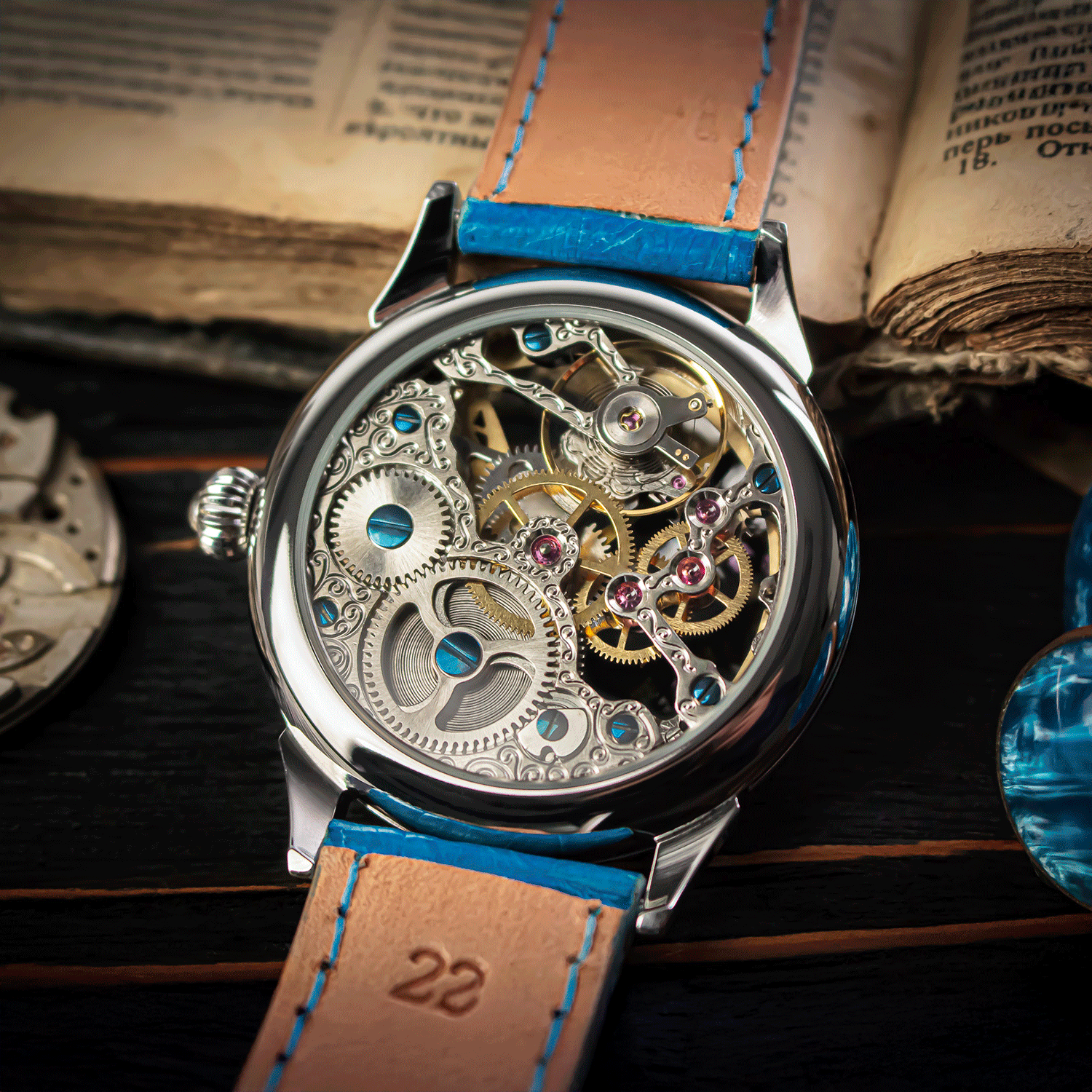 Mechanical watch with blue strap on an open book