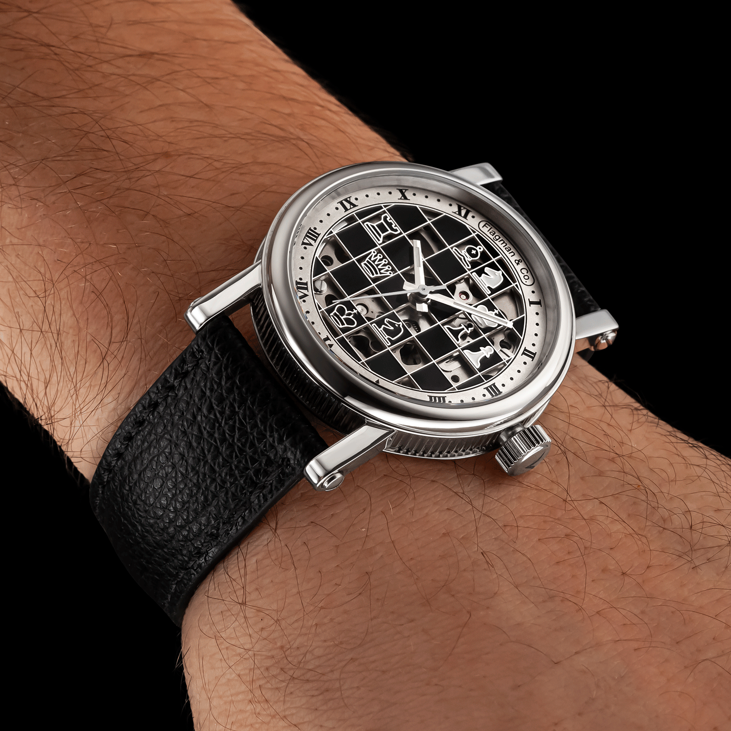 Artisan watch with black face on a wrist against a black background