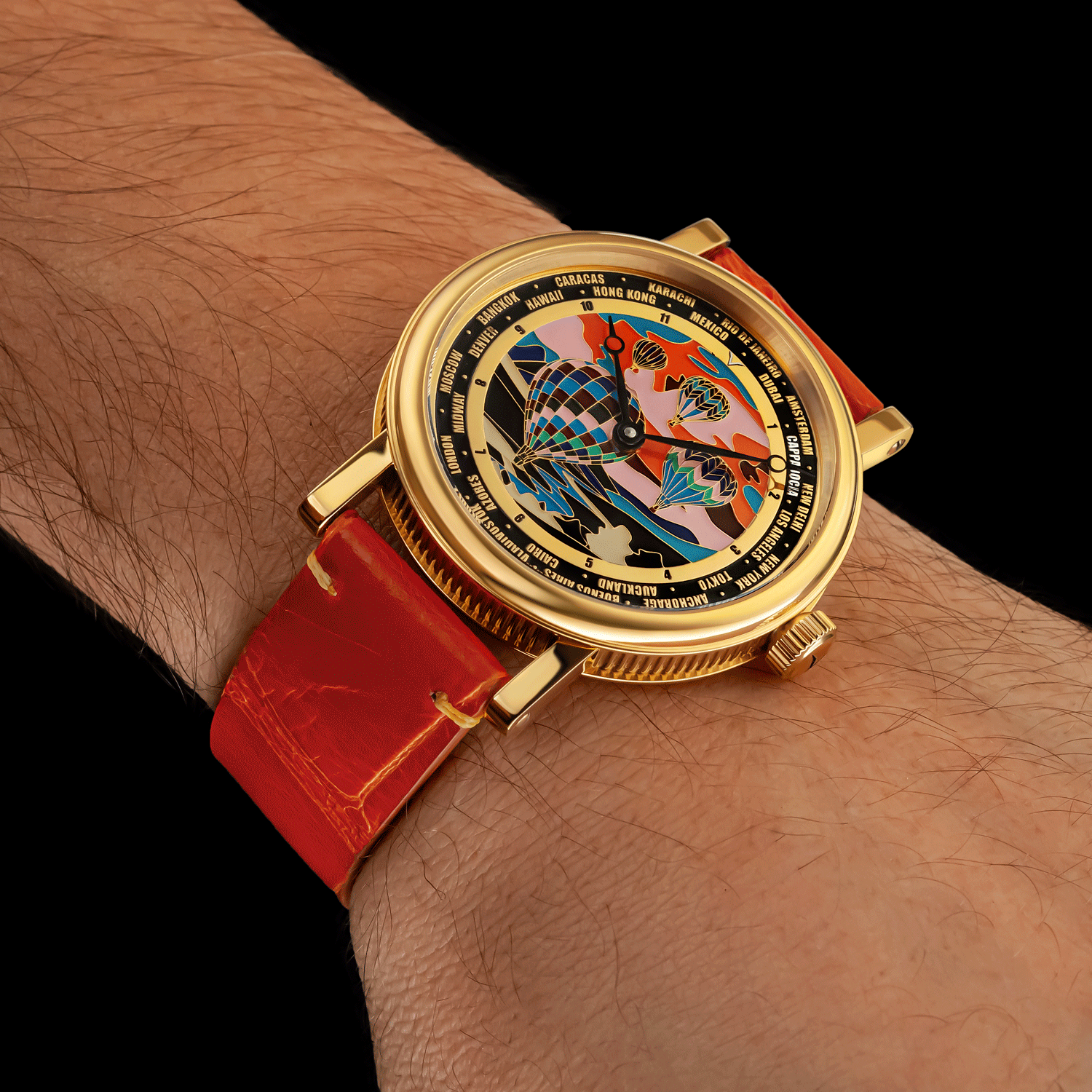 Mechanical watch with a orange strap and ornate face on a wrist against a black background
