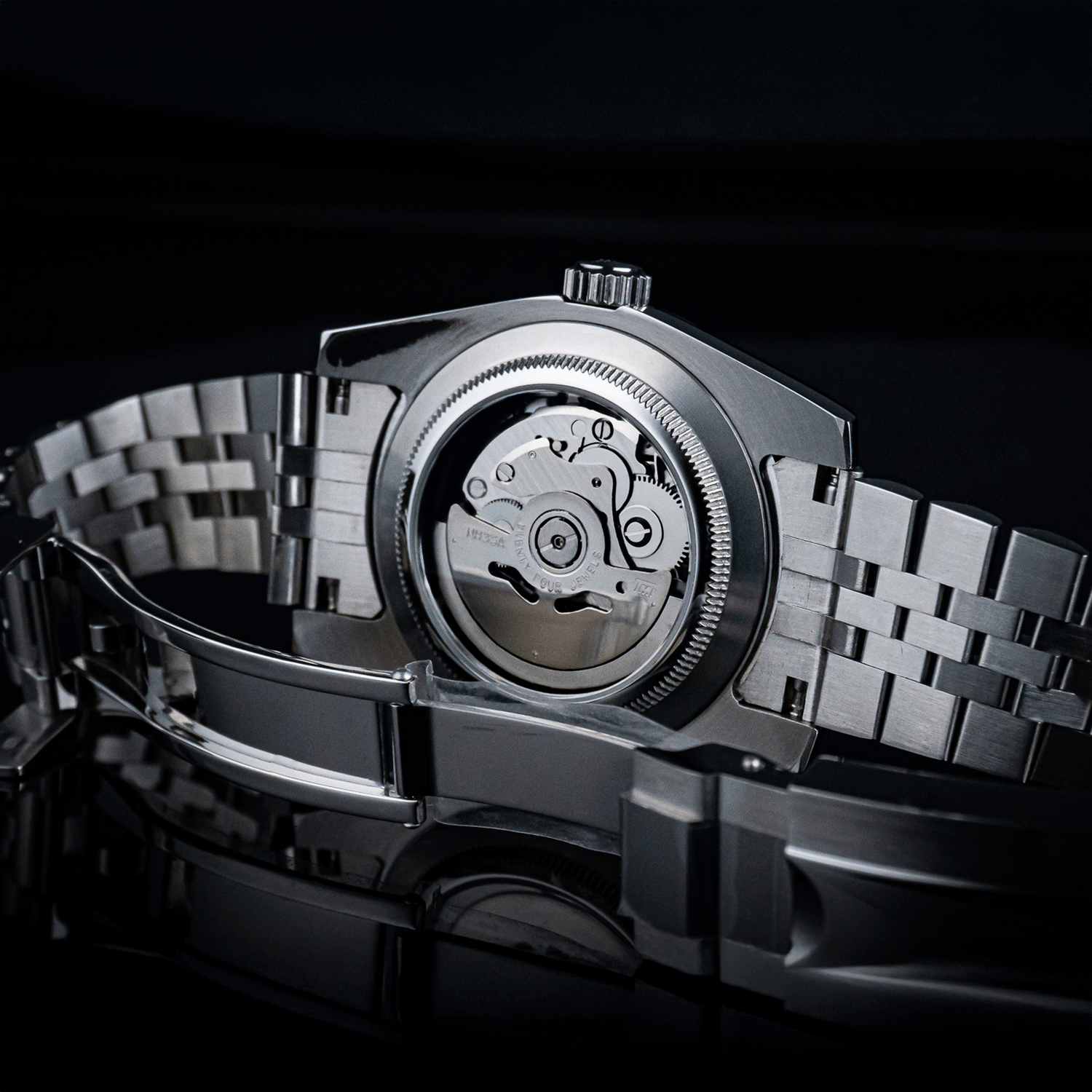 Close-up of a silver watch with a detailed mechanism on a black background