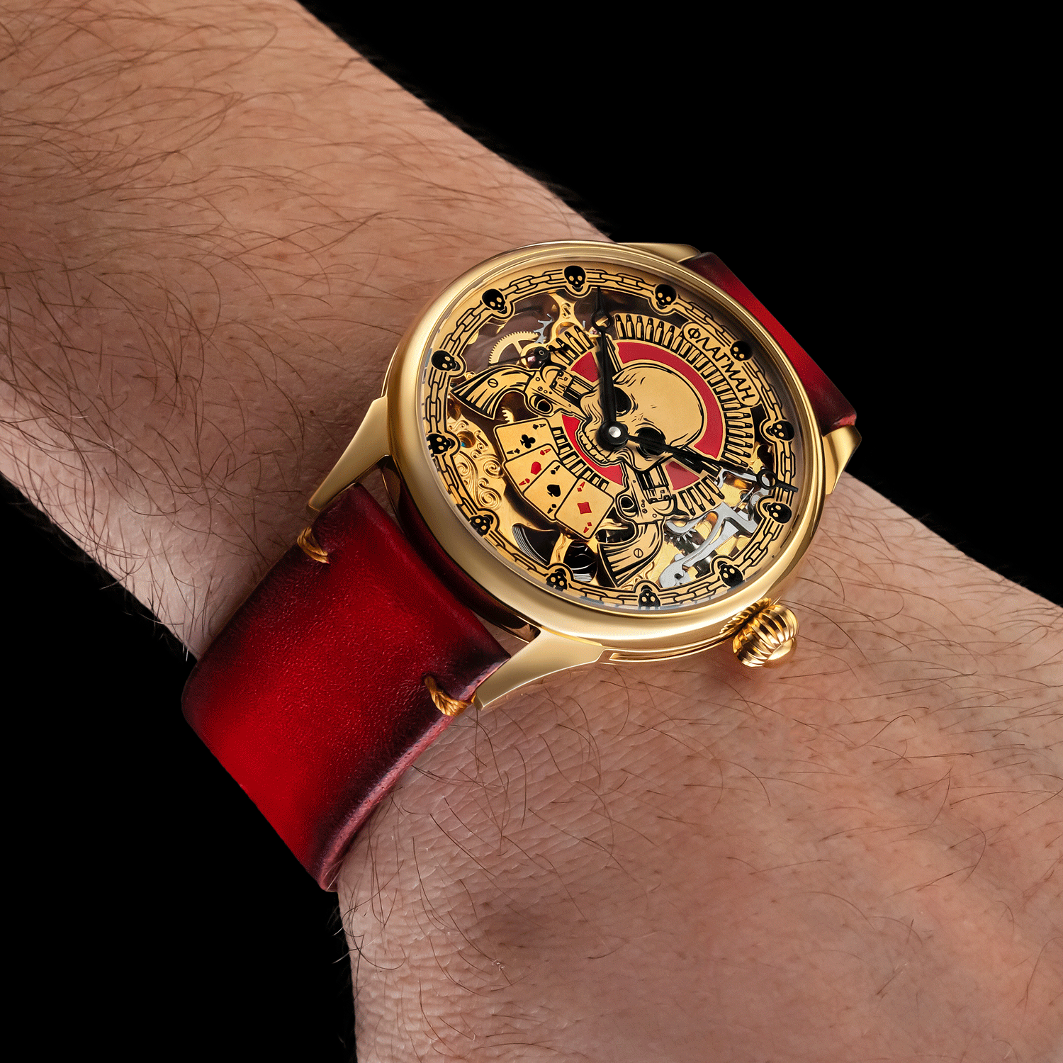 Skeleton wristwatch with red strap on a wrist against a black background