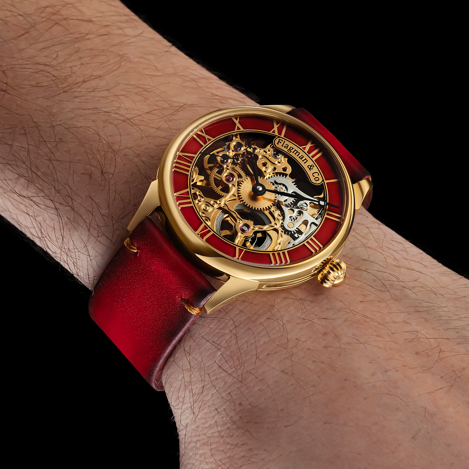 Luxury watch with red strap and gold casing on a wrist against a black background