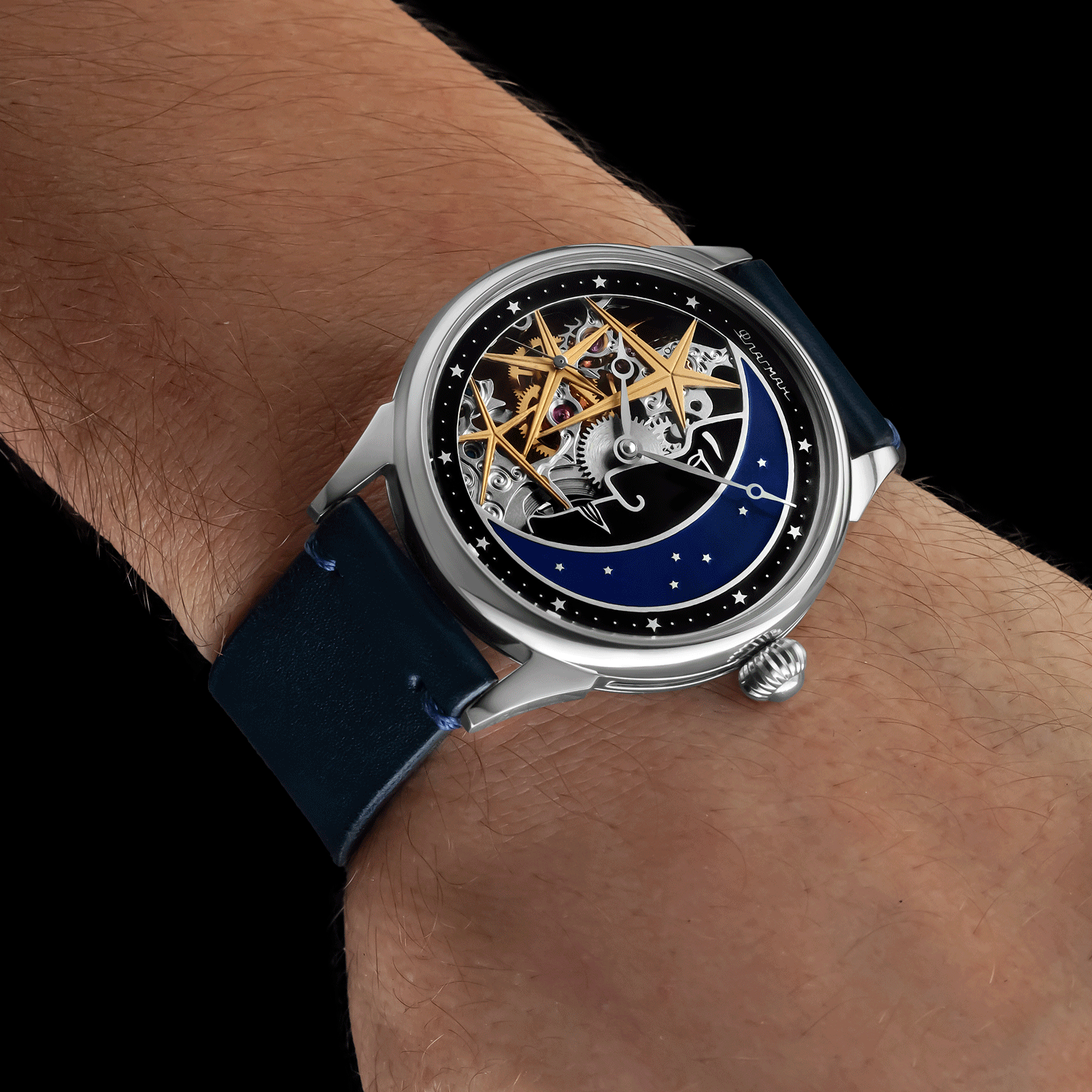 Skeleton watch with blue strap on a wrist against a black background