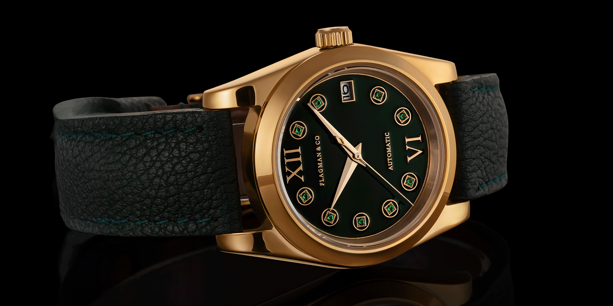 Womens watch with green strap and greenish face on a reflective surface with a black background