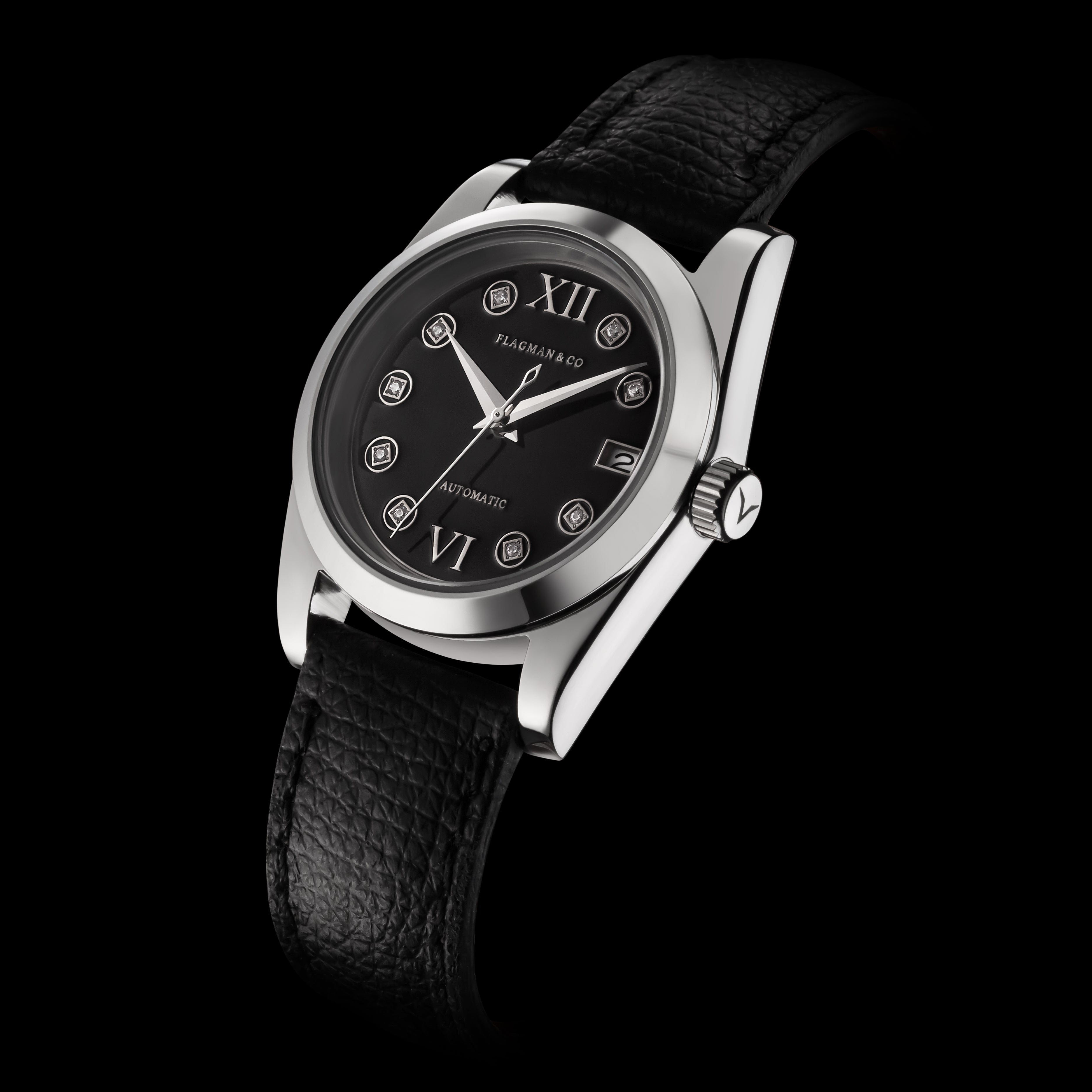 Black wristwatch with silver case and black leather strap on a black background