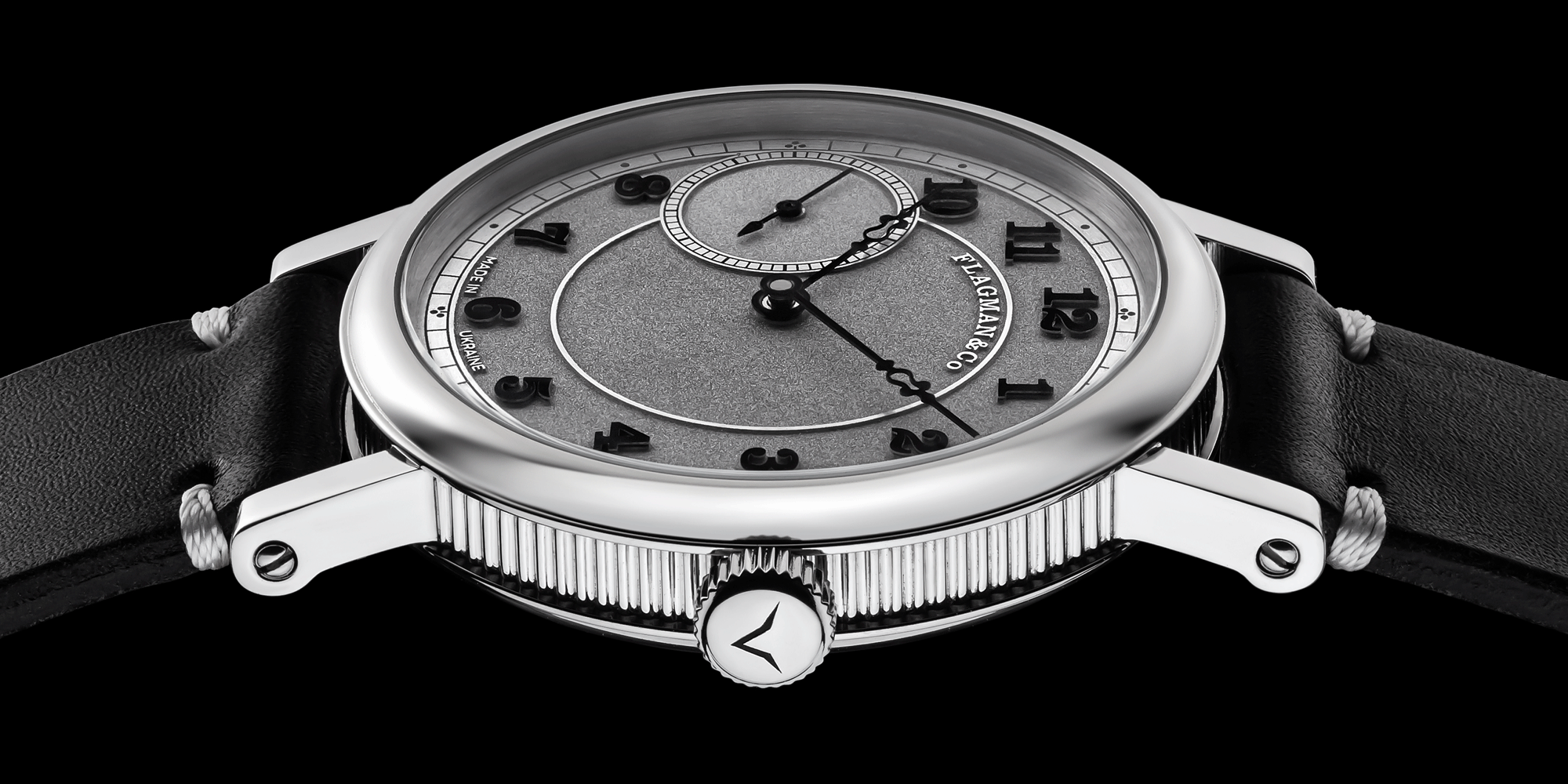 Artisan wristwatch with black leather strap on a black background