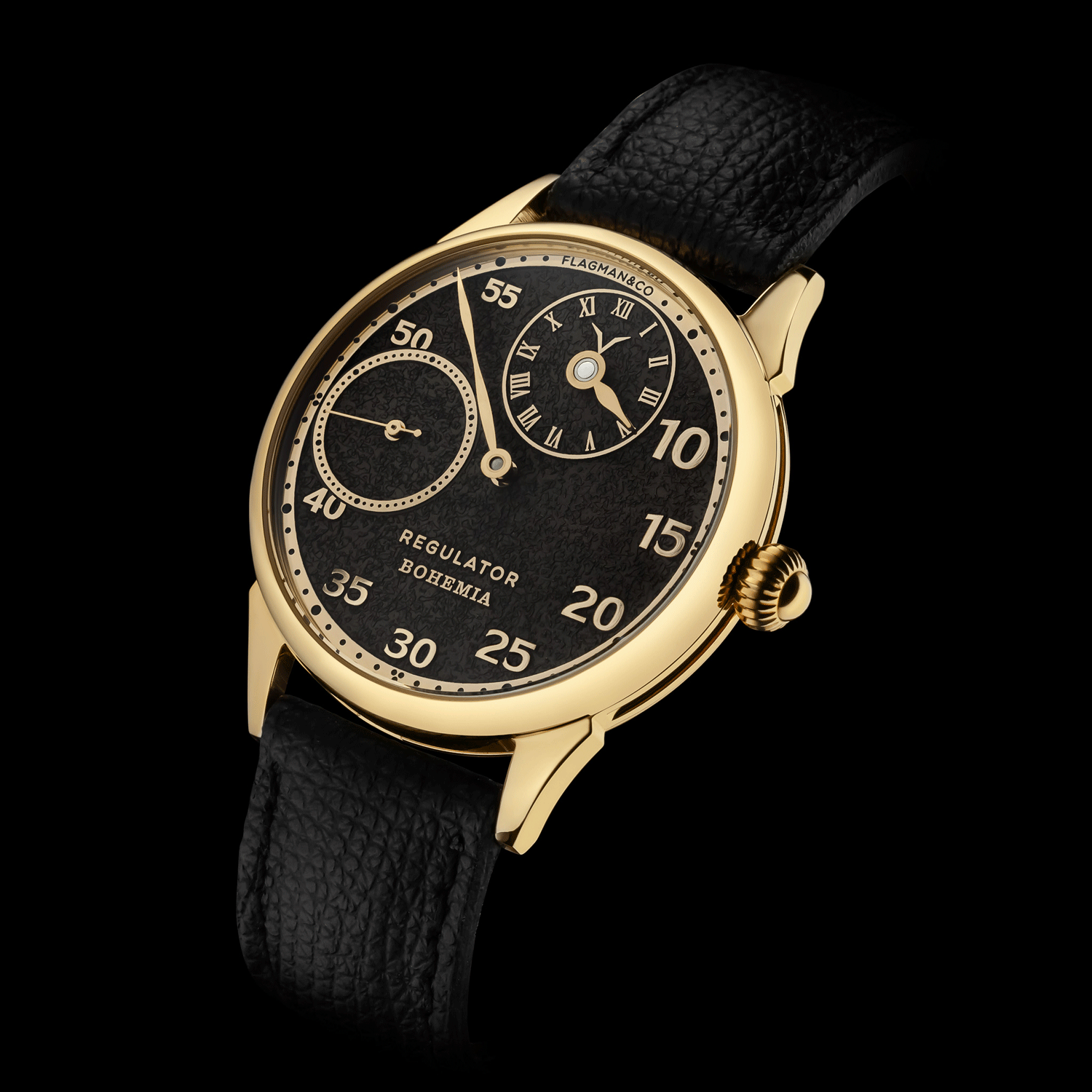 Regulator watch with black face and gold casing on a black background