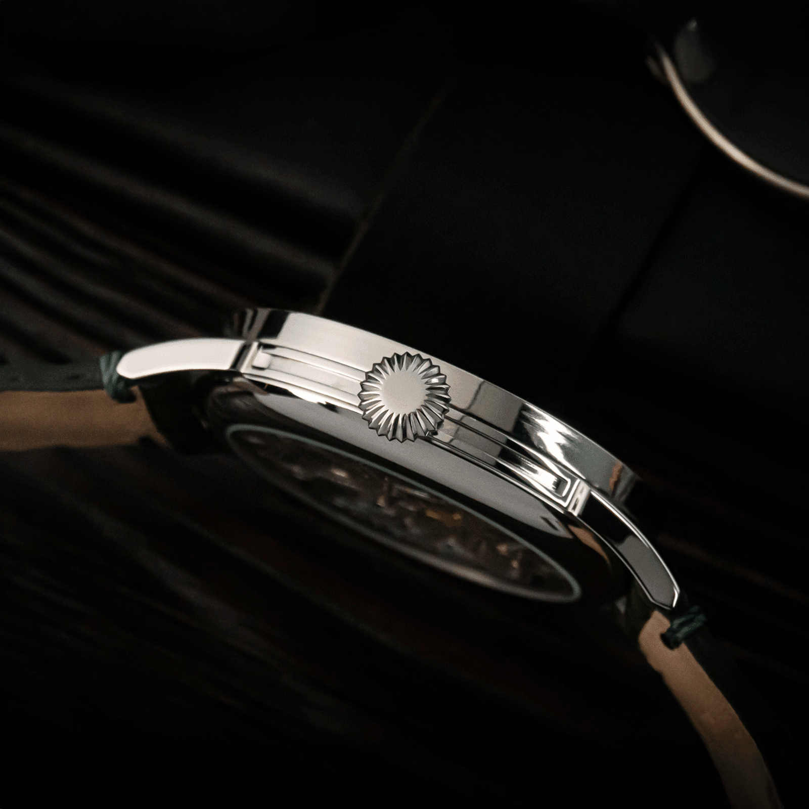 Close-up of a silver watch with a dark background