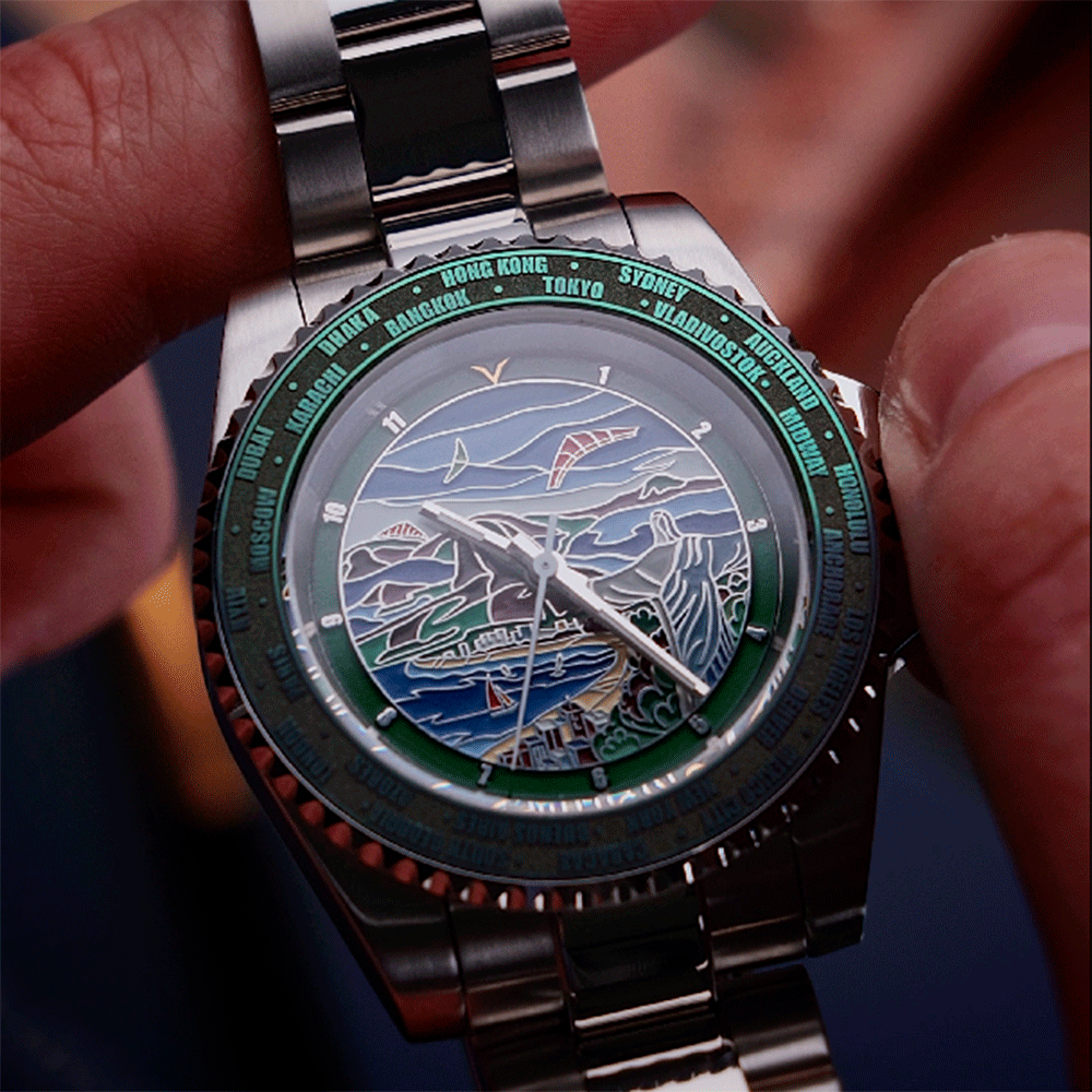 Close-up of a silver watch with a detailed face held by a hand.