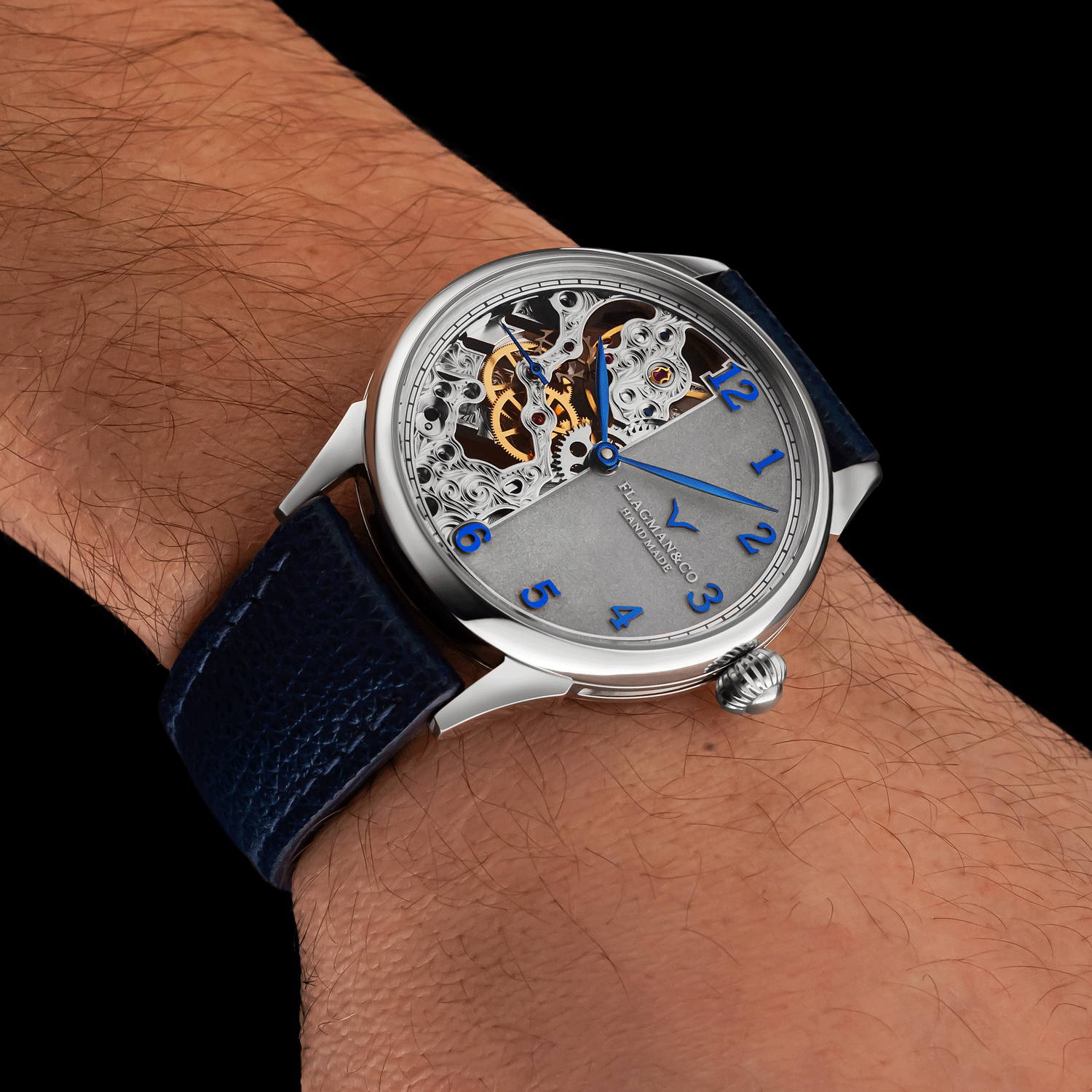 Handmade Watch with a blue strap on a wrist against a black background