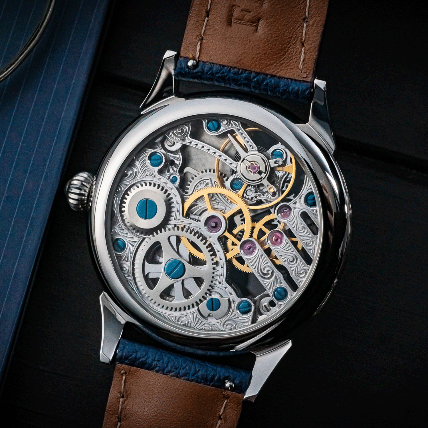 Close-up of a mechanical watch with visible gears and a Blue leather strap.