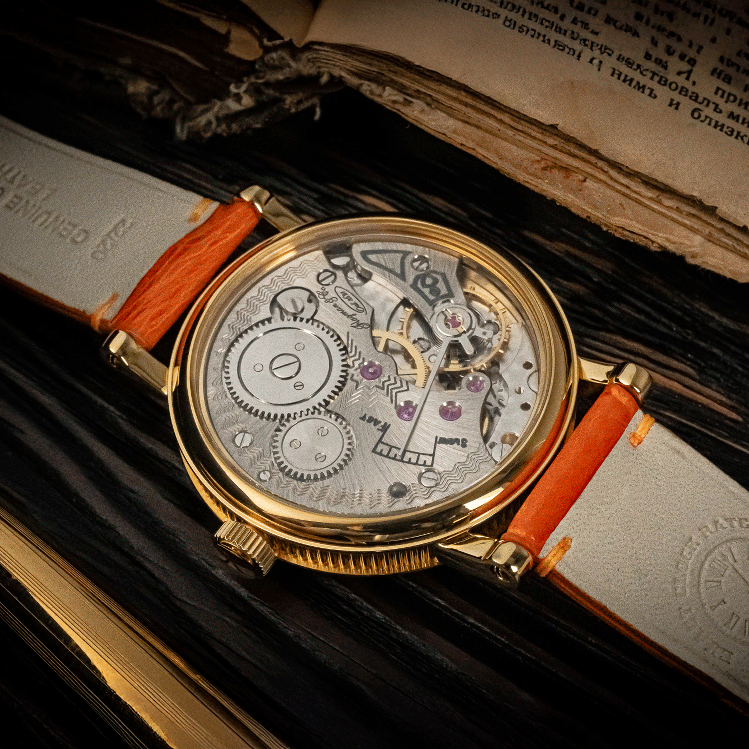 Art Deco Watch with orange strap on an open book