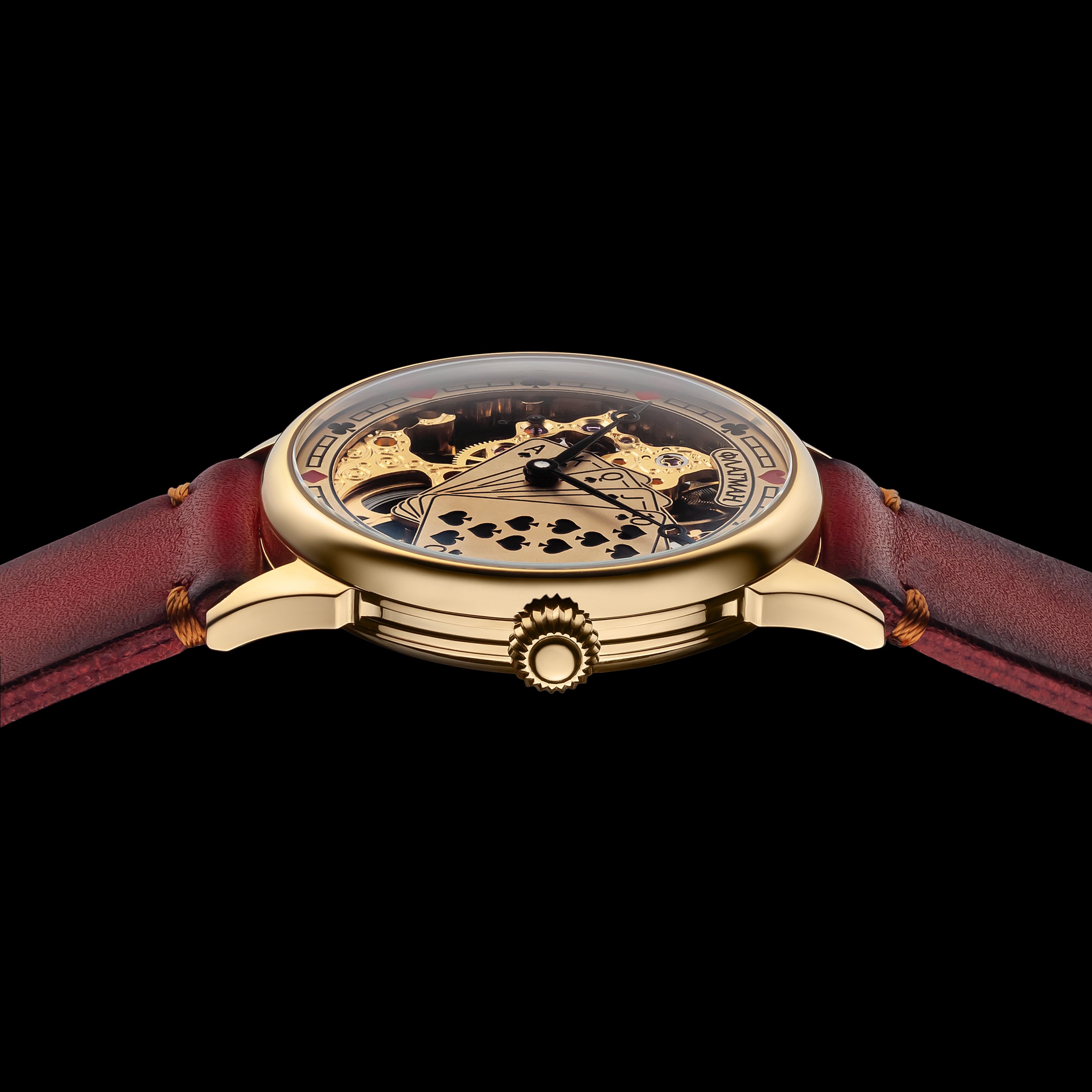 Luxury watch with red strap and gold casing on a black background
