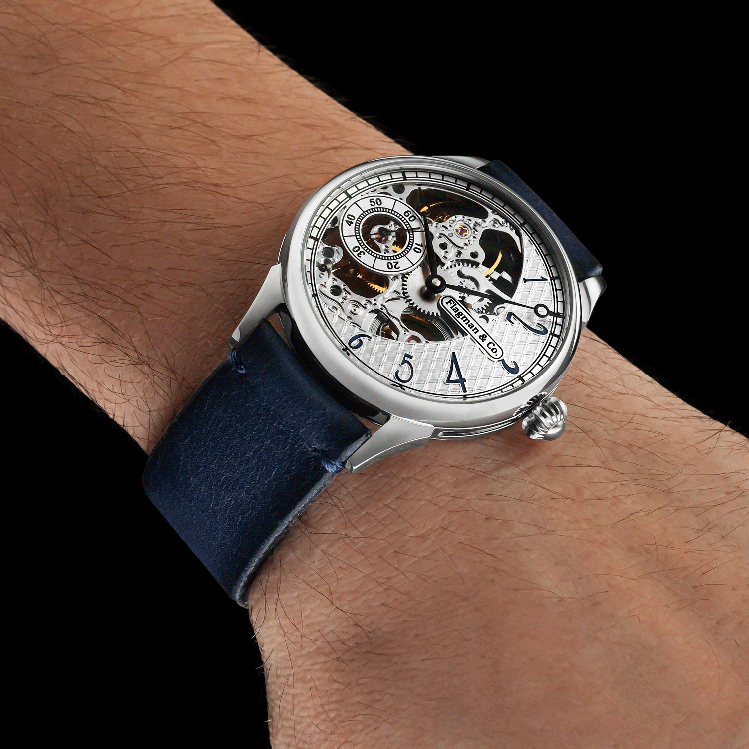 Skeleton watch with blue strap on a wrist against a black background