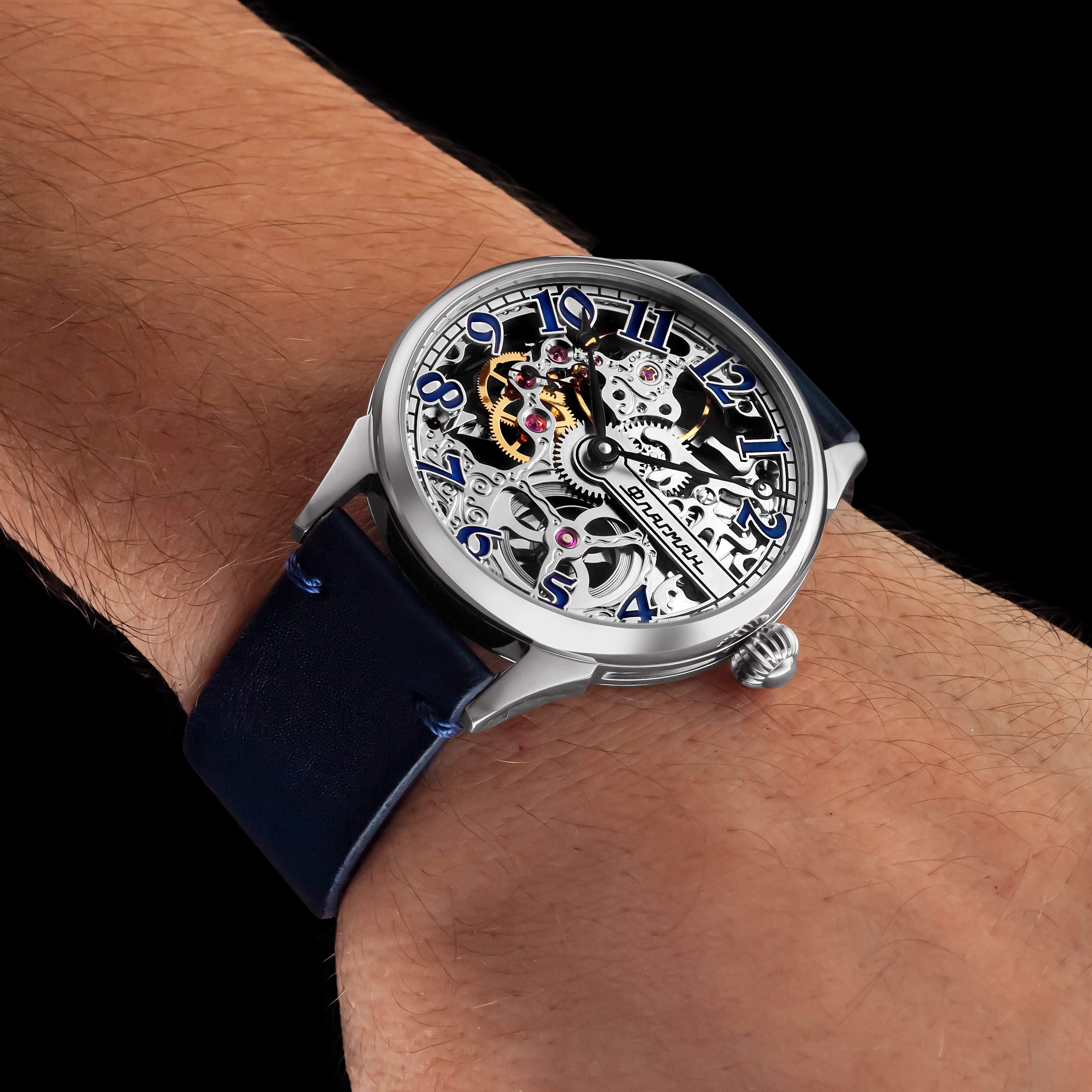 Sleek wristwatch with blue strap on a wrist against a black background