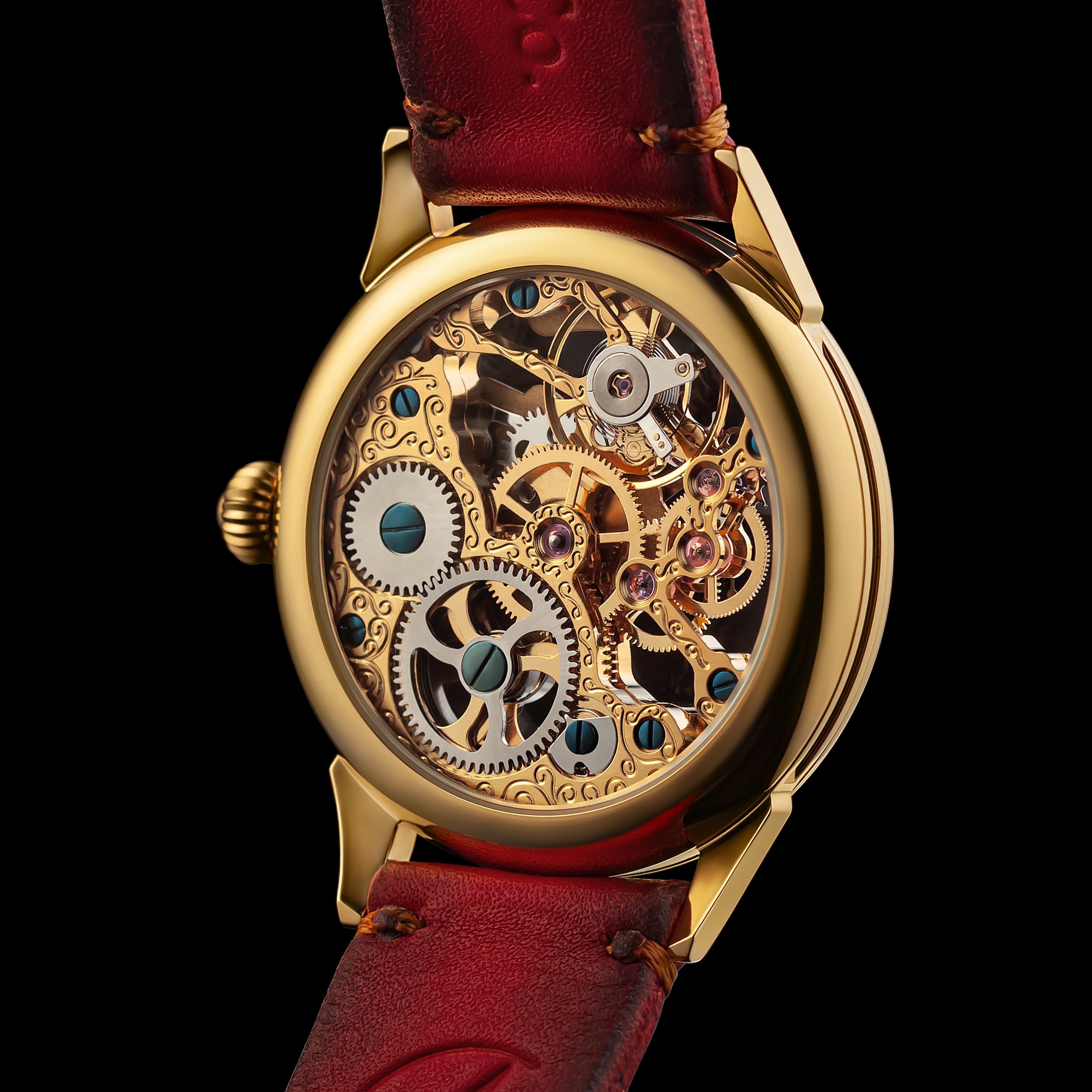 Gold mechanical watch with red leather strap on a black background